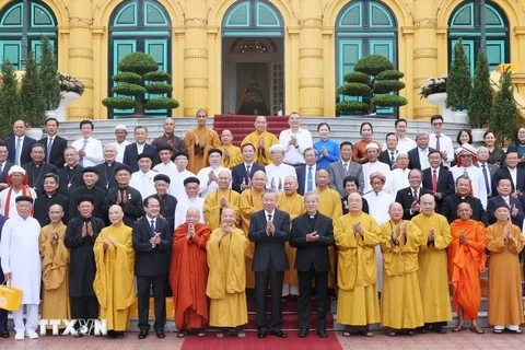 President To Lam (front, seventh from right), religious dignitaries, and officials pose for a photo at the Presidential Palace in Hanoi following their meeting on June 13 (Photo: VNA)