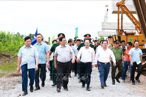 Prime Minister Pham Minh Chinh (second from left) and officials examine the construction site at Highway 61C intersection in Hau Giang Province’s Phung Hiep district on July 13 (Photo: VNA)