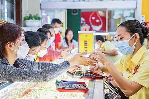 Customers purchase gold rings at a jewellery store. (Photo: cand.com.vn)