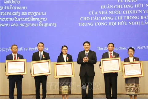 Chairman of the Vietnam-Laos Friendship Association (VLFA) Central Committee Nguyen Dac Vinh (third, right) presents the Friendship Order to 15 members of the Laos-Vietnam Friendship Association (LVFA) Central Committee (Photo: VNA)