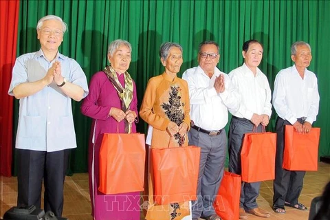 Party General Secretary Nguyen Phu Trong (first, left) gives presents to policy beneficiary families in the southern province of Soc Trang during his visit to My Xuyen district in 2015. (Photo: VNA)