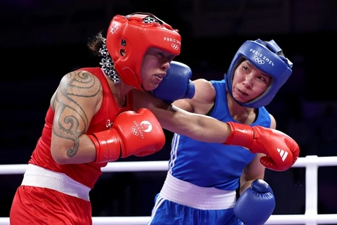 Ha Thi Linh of Vietnam (right) lands a punch on Feofaaki Epenisa from Tonga during the Paris Olympics' women's 60kg first round match on July 27. (Photo: doisongphapluat.com.vn)