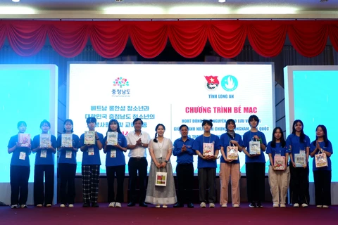 Representative of Long An province present souvenirs to the volunteer group of the Republic of Korea’s Chungcheong Nam province (Photo: VNA)