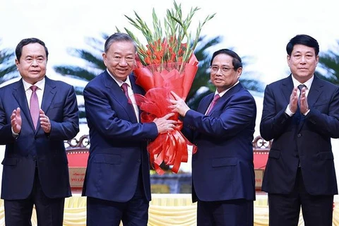 Politburo member and Prime Minister Pham Minh Chinh, on behalf of key and high-ranking leaders of the Party and State, presents flowers to congratulate Party General Secretary To Lam. (Photo: VNA)