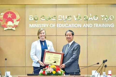 Minister of Education Nguyen Kim Son hands over the insignia "For the Cause of Education" to Rana Flowers, a Representative of the United Nations Children’s Fund (UNICEF) in Vietnam (Photo: VietnamPlus)