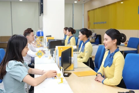 Customers make transactions at a bank in Hanoi. (Photo: chinhphu.vn)