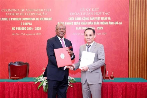 Secretary of the CPV Central Committee and Chairman of its Commission for External Relations Le Hoai Trung (R) and Politburo member and the secretary in charge of the MPLA's foreign affairs Manuel Domigos Augusto. (Photo: VNA)