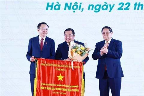 Prime Minister Pham Minh Chinh (1st from right) presents the Government's emulation flag to the representative of the Vietnam National Chemical Group. (Photo: VNA) 