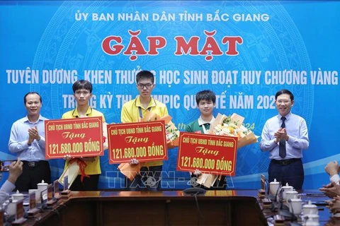 Three students who won gold medals at this year's International Olympiads receive awards at the ceremony (Photo: VNA) 