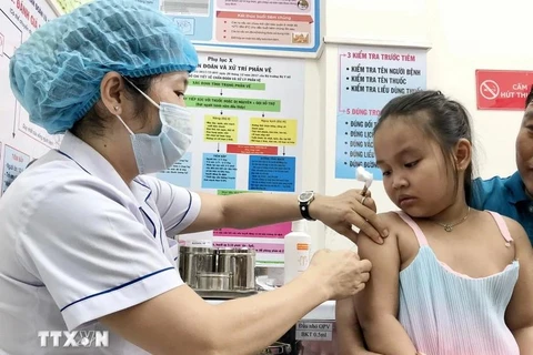 A kid gets measles jab at An Lac ward medical station in Binh Tan district. (Photo: VNA)