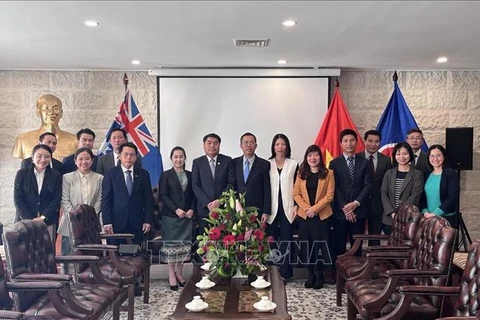 Representatives of the Vietnamese and Lao embassies in Australia pose for a group photo at the event. (Photo: VNA)