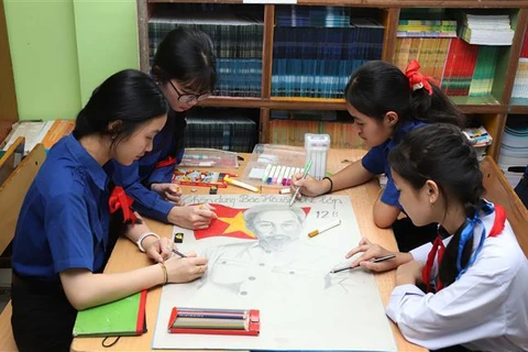 A group of students from Nguyen Du Lao-Vietnamese Bilingual School draw a picture of Uncle Ho. (Photo: VNA)