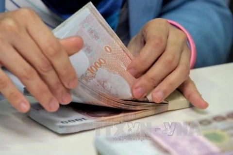 Counting Thai baht at Krung Thai Bank in Bangkok. (Photo: AFP/VNA)