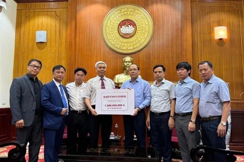 Representatives of the Overseas Vietnamese in Russia hand over 1.5 billion VND to the Vietnam Fatherland Front to support people suffering damage due to Typhoon Yagi in the homeland. (Photo: VNA)