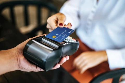 A customer uses a card for payment at a point-of-sale (Photo: VNA).