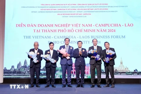 Vice Chairman of the Ho Chi Minh City People's Committee Bui Xuan Cuong (3rd from right) gives flowers to representatives of the forum organising board. (Photo: VNA)