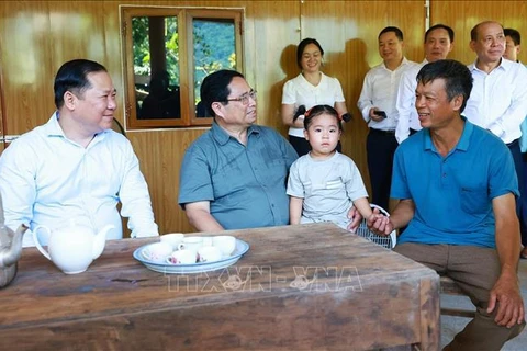 Prime Minister Pham Minh Chinh (second, left) visits a family benefited from the movement to build and repair houses for the needy in Hien Luong commune in Da Bac district of Hoa Binh province. (Photo: VNA)