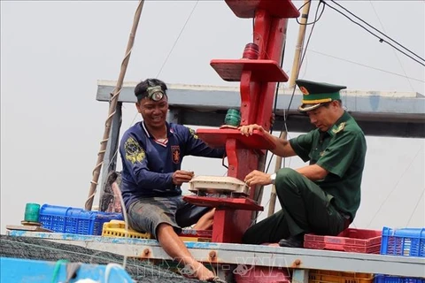 A fishing ship owner and an officer of the Phu Yen provincial Border Guard Command inspect the vessel monitoring system (VMS) on a fishing boat. (Photo: VNA)