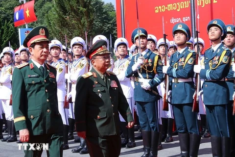 Vietnamese Minister of National Defence Gen. Phan Van Giang (left) and his Lao counterpart Gen. Chansamone Chanyalath inspect the guard of honour at the second Vietnam-Lao border defence friendship exchange on October 22. (Photo: VNA)