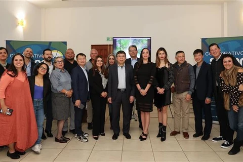 The Vietnamese Embassy delegation take a group photo with typical businesses in Central Mexico. (Photo: VNA)