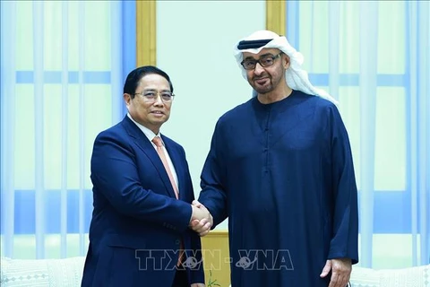 Prime Minister Pham Minh Chinh (L) shakes hands with President of the United Arab Emirates (UAE) Sheikh Mohammed bin Zayed Al Nahyan (Photo: VNA)