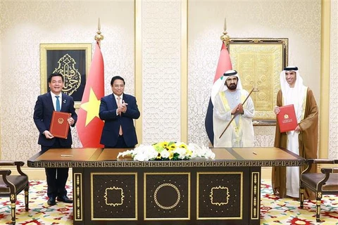 Prime Minister Pham Minh Chinh (second from left) and UAE Vice President and Prime Minister Sheikh Mohammed bin Rashid Al Maktoum (second from right) witness the signing of Comprehensive Economic Partnership Agreement (CEPA) between Vietnam and the United Arab Emirates (UAE) (Photo: VNA)