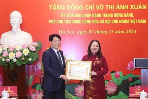 State President Luong Cuong present a 30-year Party membership badge to Vice President Vo Thi Anh Xuan (Photo: VNA)