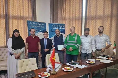 Vietnamese Ambassador to Algeria Tran Quoc Khanh (third from left) and representatives of several firms in Biskra. (Photo: VNA)