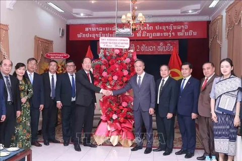 Permanent Deputy Secretary of the Ho Chi Minh City Party Committee Nguyen Ho Hai (left) presents a bouquet to Deputy Consul General of Laos in the city Amphay Souvannaseng. (Photo: VNA)