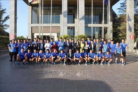 Representatives of the Vietnamese Embassy in Laos and the Vietnamese national men's football team pose for a group photo. (Photo: VNA)