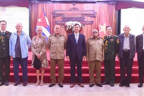 Ambassador Le Quang Long (centre) and Defence AttachéColonel Bui Xuan Phong (third, right), take a photo with Cuban war veterans. (Photo: VNA)