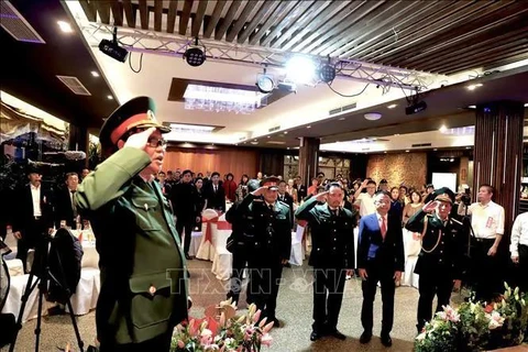 Delegates observe the flag-hoisting ceremony at the event (Photo: VNA)