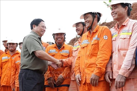 El primer ministro de Vietnam, Pham Minh Chinh, y los trabajadores en la obra. Foto de : VNA