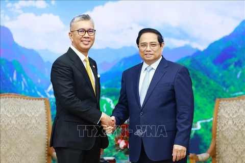 El primer ministro de Vietnam, Pham Minh Chinh (derecha), recibe al ministro de Inversión, Comercio e Industria de Malasia, Zafrul Abdul Aziz. (Foto: VNA)