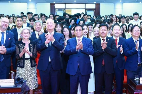 El primer ministro Pham Minh Chinh, el fundador y presidente ejecutivo del FEM, Klaus Schwab, y casi 500 estudiantes de universidades en Hanoi (Foto: VNA)