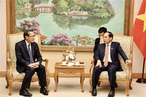 El vicepremier y ministro de Relaciones Exteriores de Vietnam, Bui Thanh Son (derecha), intercambia con el ministro de Energía y Minas de Laos, Phosay Sayasone. (Foto: VNA)