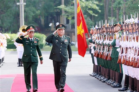 El general Phan Van Giang, subsecretario de la Comisión Militar Central y ministro de Defensa de Vietnam, y Zhang Youxia, vicepresidente de la Comisión Militar Central de China, pasan revista a la guardia de honor (Foto: VNA)