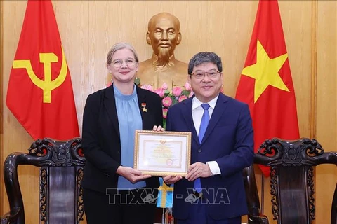 L'ambassadrice de Suède au Vietnam reçoit un insigne pour sa contribution à l'enseignement de la théorie politique. Photo : VNA