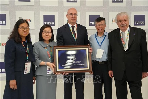 La directrice générale adjointe de la VNA Doan Thi Tuyet Nhung (2e, gauche) offre un souvenir au directeur général de l'agence de presse TASS, Andrey Kondrashov. Photo : VNA