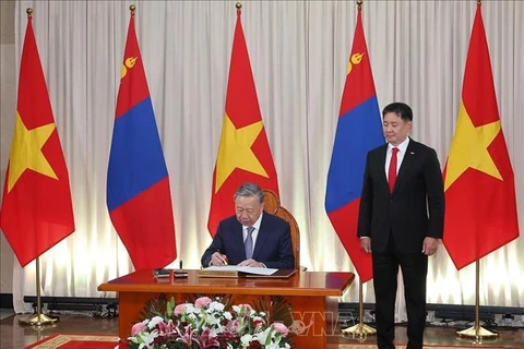 Le secrétaire général du Parti communiste du Vietnam et président de l'Etat, To Lam, signe le livre d'or d'honneur en présence du président mongol Ukhnaagiin Khurelsukh à Oulan-Bator, le 30 septembre. (Photo : VNA)