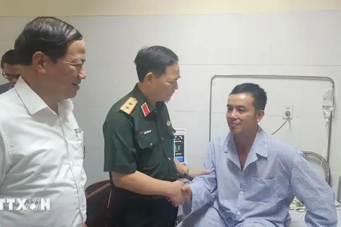 越南人民军副总参谋长范长山中将看望慰问遇险飞行员。图自越通社