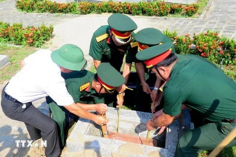 Lors de la céréminie d'inhumation des restes de 15 soldats volontaires et experts vietnamiens tombés au Laos et au Cambodge. Photo: VNA