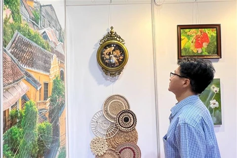 A visitor to the Hong Kong art expo watches Vietnamese products on display. (Photo: VNA)