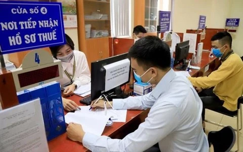 A tax official assists a man in filling out his tax returns in the capital city of Hanoi. (Photo: VNA) 