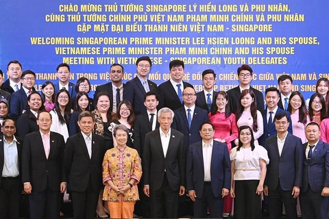 Prime Minister Pham Minh Chinh (seventh from right) and then Singaporean Prime Minister Lee Hsien Loong (eighth from right), officials, and youth delegates at the Vietnam - Singapore youth leaders exchange programme 2023 in Hanoi on August 29. (Photo: VNA)