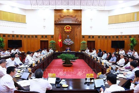 Prime Minister chairs a meeting between permanent Cabinet members and representatives of ministries and agencies on inflation control on June 8. (Photo: VNA)