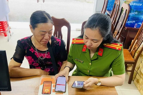 A police officer instruct a resident in Tien Yen district, Quang Ninh province to use app VNeID. (Photo: congan.quangninh.gov.vn)