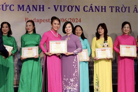 Ambassador Nguyen Thi Bich Thao presents certificates of merit to members of the Vietnamese women's union in Hungary for their contributions to its activities. (Photo: VNA)