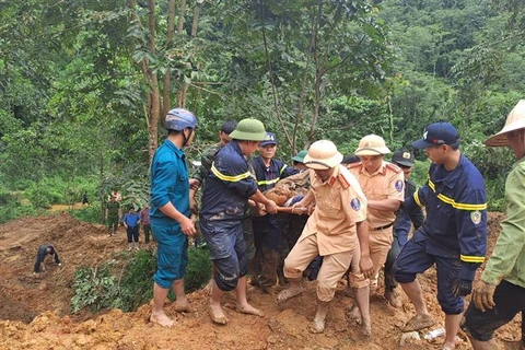 Rescuers find a victim after a mini bus is buried by a landslides in the mountainous province of Ha Giang on July 13. (Photo: VNA)