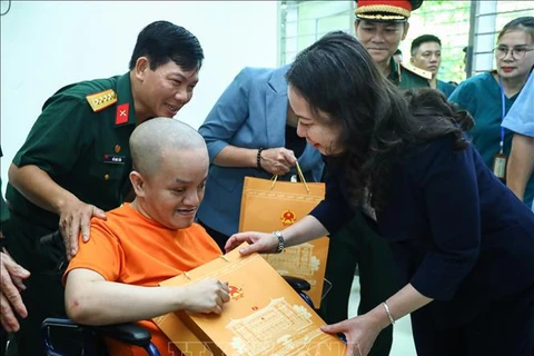 Vice President Vo Thi Anh Xuan gives a gift to an AO victims at the centre for caring, nurturing and treating victims of AO/dioxin in Ba Vi district, Hanoi. (Photo: VNA)